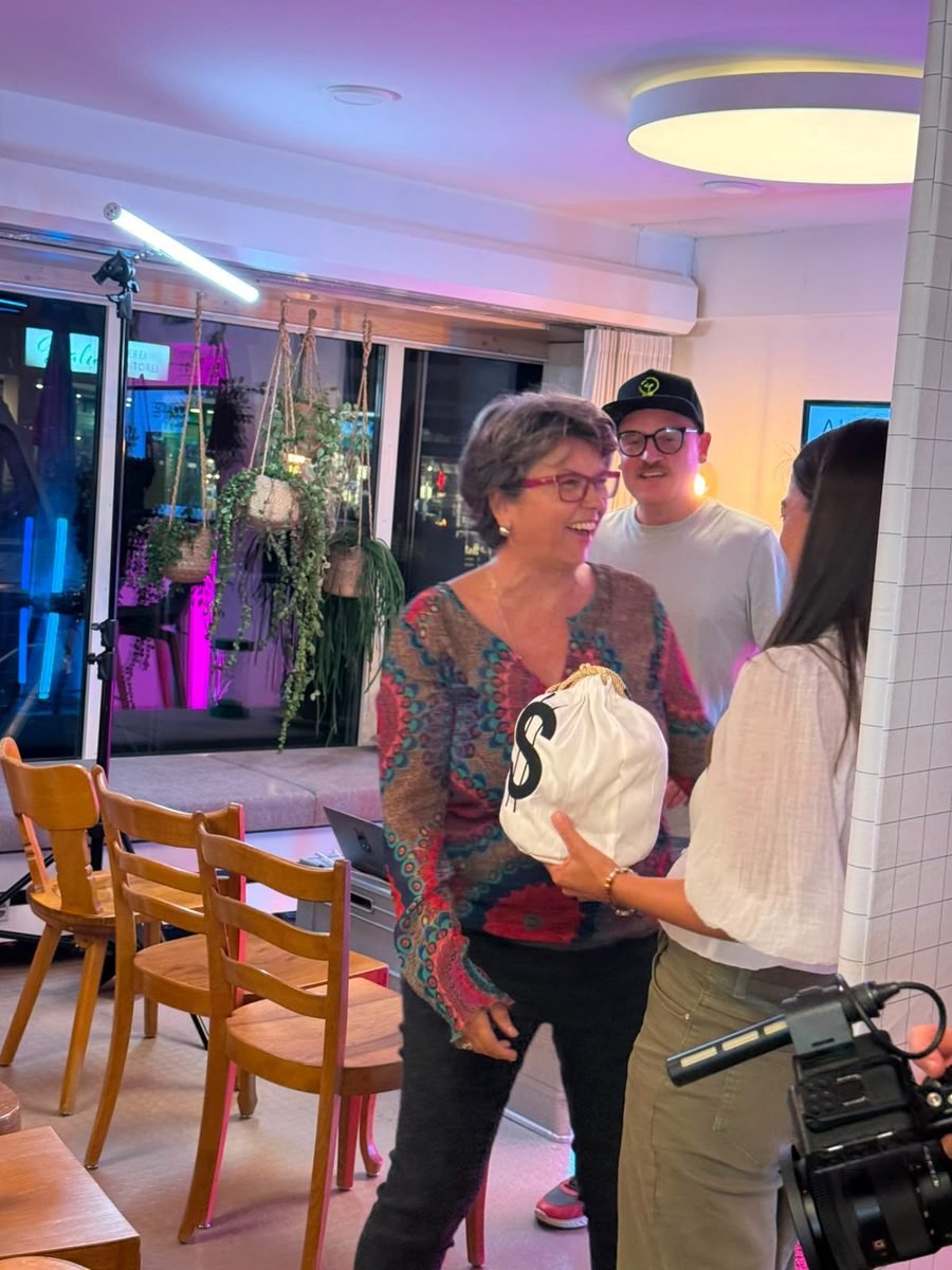 Claudia Doron hält den Gewinn-Sack in den Händen und lacht, neben ihr Rosaria Michaela Ackermann.